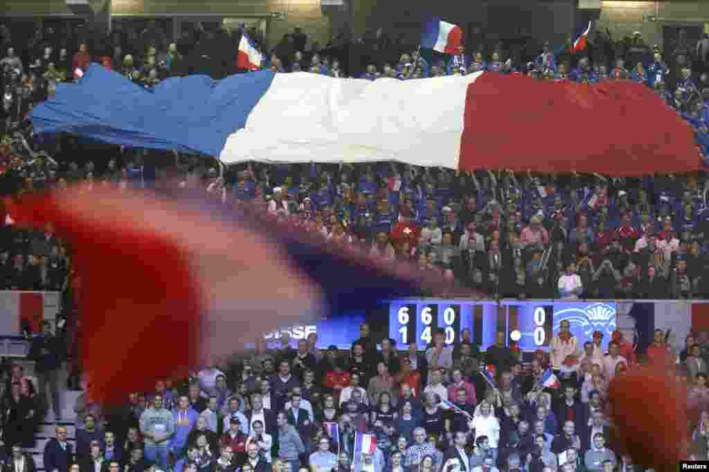 France Davis Cup fans hold a giant flag as they cheer on France&#39;s Gael Monfils during his Davis Cup final singles tennis match against Switzerland&#39;s Roger Federer at the Pierre-Mauroy stadium in Villeneuve d&#39;Ascq, near Lille.