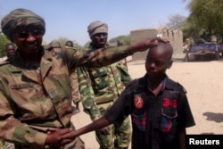 FILE - A Chadian soldier embraces a former child soldier of insurgent group Boko Haram in Ngouboua, Chad, April 22, 2015. The young men said they were Chadian nationals forced to join Boko Haram while studying the Quran in Nigeria, and that they escaped and turned themselves in to Chadian authorities.