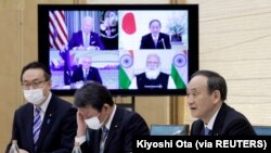 Yoshihide Suga, Perdana Menteri Jepang, berbicara sementara monitor menampilkan Presiden AS Joe Biden, Perdana Menteri Australia Scott Morrison dan Perdana Menteri India Narendra Modi, selama pertemuan Virtual Quadrilateral Security Dialogue (Quad) di ked