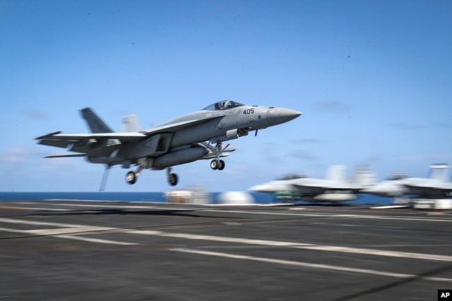 FILE - An F/A-18E Super Hornet lands on the flight deck of the Nimitz-class aircraft carrier USS Abraham Lincoln in the Arabian Sea, May 20, 2019.