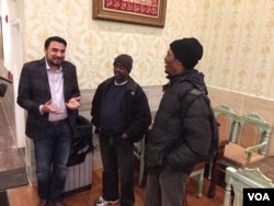 Kazi Mannan speaks with two of his regular homeless guests at his restaurant, which welcomes paying and non-paying customers. (J. Taboh/VOA)