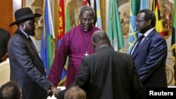 Le chef rebelle sud-soudanais Riek Machar (D) et le président Salva Kiir (G) lors d'une prière avant de signer un accord de paix à Addis Abeba, le 9 mai 2014.
