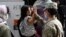 FILE - Army Pfc. Kimberly Hernandez gives a high-five to a girl evacuated from Kabul, before boarding a bus after they arrived at Washington Dulles International Airport, Aug. 30, 2021.