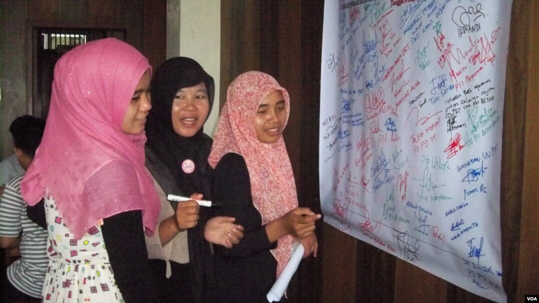 Penandatanganan petisi warga desak pemerintah wujudkan RUU perlindungan PRT mengisi kegiatan Hari Perempuan Sedunia Aceh. (VOA/Budi Nahaba)