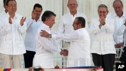 El presidente colombiano Juan Manuel Santos y el ex comandante guerrillero, Rodrigo Londoño, se estrechan las manos durante el acto de firma de la paz en Cartagena.