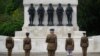 FILE - Senior officers and soldiers of the Household Division stand in front of Guards Memorial in St James's Park during a two minute silence to commemorate the 75th Anniversary of VE Day, London, May 8, 2020.