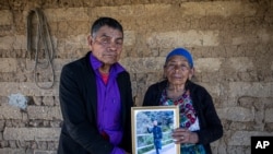 Germán y María Tomas posan con una fotografía de su nieto Gaudiel, quien presumen asesinado en la matanza de Tamaulipas, en su casa de Comitancillo, Guatemala, el 27 de enero de 2021.