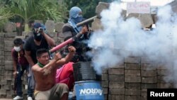 Un manifestante dispara un arma de fabricación casera contra un policía durante una protesta contra el gobierno del presidente de Nicaragua, Daniel Ortega, en Masaya, Nicaragua, el martes, 19 de junio de 2018.