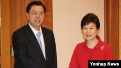 박근혜 한국 대통령이 11일 청와대를 방문한 장더장 중국 전국인민대표회의 상무위원장(왼쪽)과 인사하고 있다.