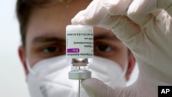FILE: Medical staff prepares a syringe from a vial of the AstraZeneca coronavirus vaccine during preparations at the vaccine center in Ebersberg near Munich, Germany, March 22, 2021.