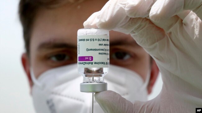 FILE: Medical staff prepares a syringe from a vial of the AstraZeneca coronavirus vaccine during preparations at the vaccine center in Ebersberg near Munich, Germany, March 22, 2021.