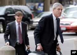 FILE - In this April 21, 2016 file photo, attorney and former FBI Director Robert Mueller, right, arrives for a court hearing at the Phillip Burton Federal Building in San Francisco.