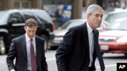 FILE - In this April 21, 2016, file photo, attorney and former FBI Director Robert Mueller (right) arrives for a court hearing at the Phillip Burton Federal Building in San Francisco.