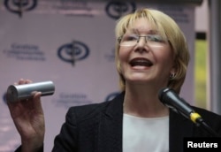Venezuela's Chief Prosecutor Luisa Ortega Diaz holds up the kind of tear gas canister used by security forces to disperse anti-government protests, as she speaks to the press at her office in Caracas, Venezuela, May 24, 2017.