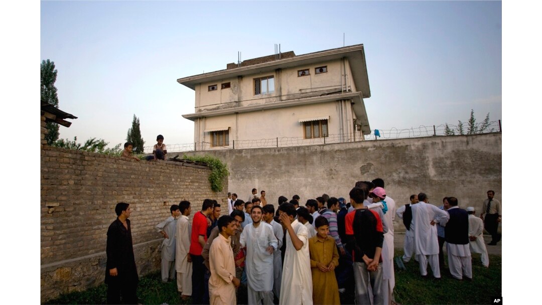 FILE - In this May 3, 2011, photo, local residents gather outside a compound where al-Qaida leader Osama bin Laden was killed by U.S. forces, in Abbottabad, Pakistan.