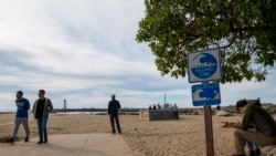 People watch waters rise from Twin Lakes State Beach in Santa Cruz, Calif., Jan. 15, 2022.