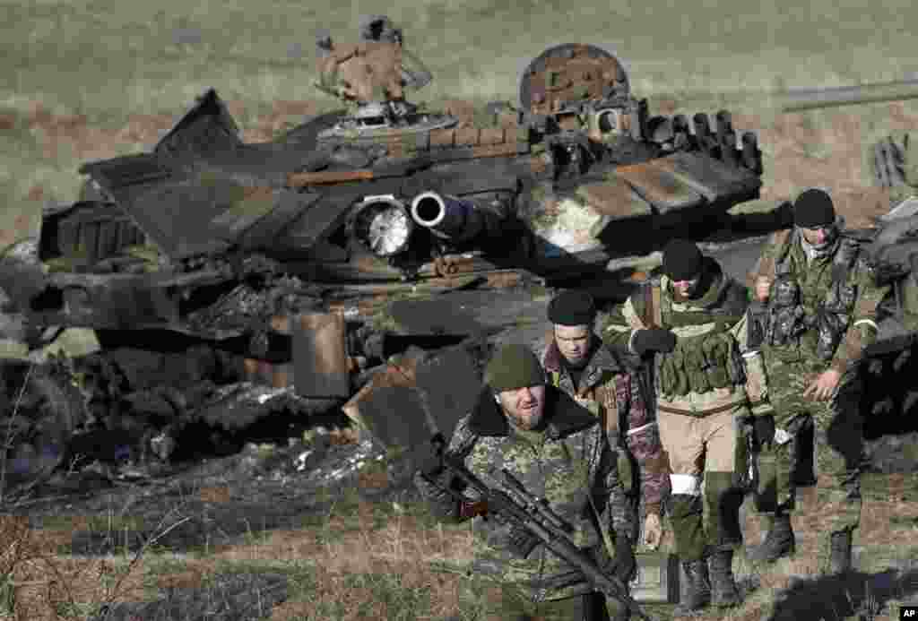 Russia-backed separatists inspect destroyed Ukrainian army tanks near the village of Lohvynove, outside Debaltseve, Ukraine, Feb. 22, 2015.