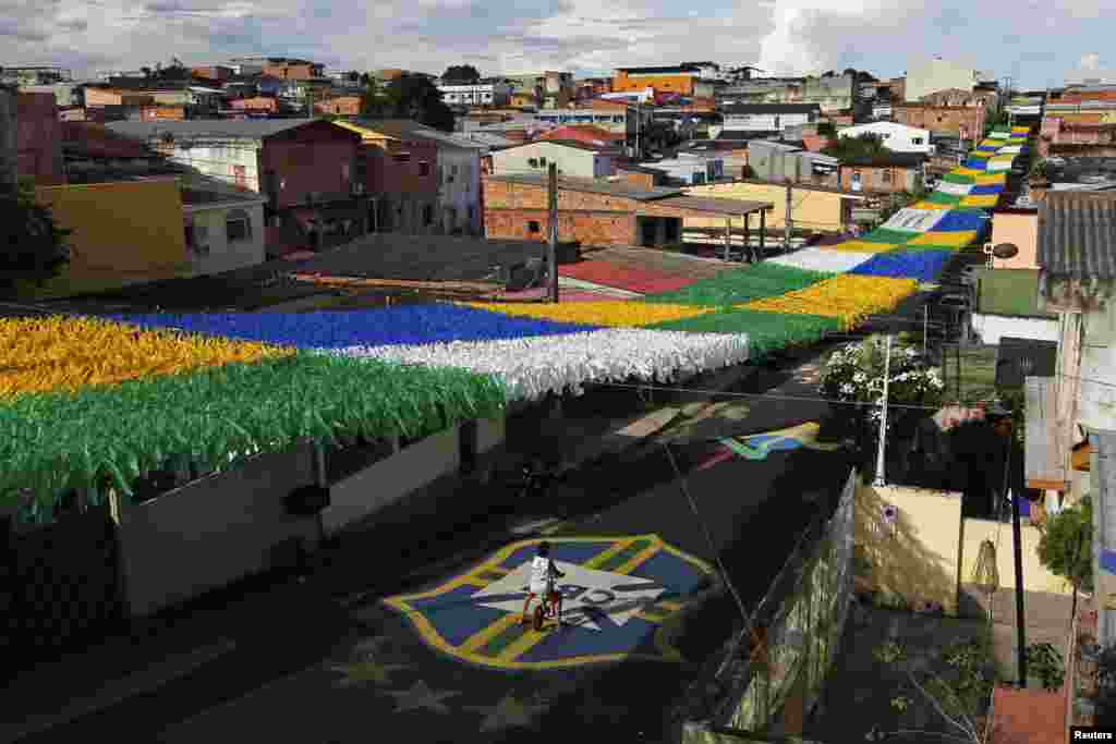 A boy rides his bicycle along Third Street of the Alvorada neighborhood in Brazil which is decorated for the 2014 World Cup in Manaus, one of the tournament&#39;s host cities, May 17, 2014.