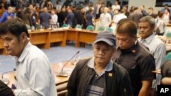 Mantan anggota milisi Filipina Edgar Matobato (tengah) dikawal secara ketat setelah bersaksi di Senat, di Pasay, bagian selatan Manila (15/9). (AP/Aaron Favila)