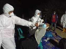 Petugas kesehatan Aceh Timur melakukan tes swab terhadap salah satu pengungsi Rohingya, Jumat (4/6). (Foto: VOA/Anugrah)