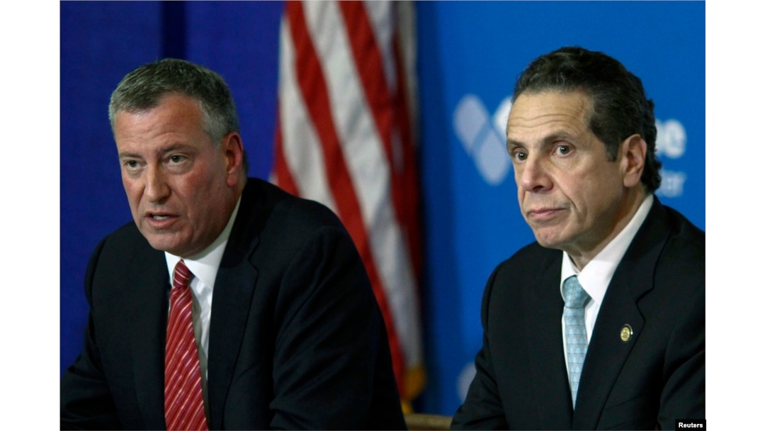 New York City Mayor Bill de Blasio, left, and New York Gov. Andrew Cuomo discuss the city's first confirmed Ebola case at a news conference at New York's Bellevue Hospital Oct. 23, 2014.