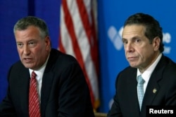 New York City Mayor Bill de Blasio, left, and New York Gov. Andrew Cuomo discuss the city's first confirmed Ebola case at a news conference at New York's Bellevue Hospital Oct. 23, 2014.