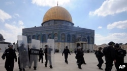 FILE - In this Friday, Oct. 5, 2012, photo, Israeli forces take position during clashes with Palestinian worshippers at the Al-Aqsa Mosque compound in Jerusalem's Old City.