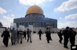 FILE - In this Friday, Oct. 5, 2012, photo, Israeli forces take position during clashes with Palestinian worshippers at the Al-Aqsa Mosque compound in Jerusalem's Old City.