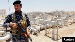 18일 이라크 바그다드 남동부의 주바이르 정유시설을 무장 병력이 지키고 있다. 북부 바이지 정유시설은 전날 무장 반군의 공격을 받았다.