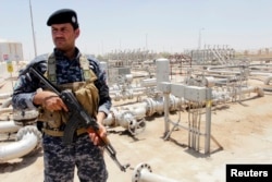 A member from the oil police force stands guard at Zubair oilfield in Basra, southeast of Baghdad, June 18, 2014.