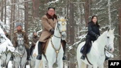 Pemimpin Korea Utara, Kim Jong-un (tengah) menunggang kuda putih saat berkunjung ke lokasi pertempuran di Gunung Paektu, Ryanggang, 4 Desember 2019. (Foto: STR/KCNA via KNS/AFP)