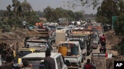 This photo provided by Nabaa Media, a Syrian opposition media outlet, shows people in their vehicles fleeing from Daraa, southern Syria, June 28, 2018. Government forces are on the offensive against insurgents as more people fled their homes, where they are living in miserable conditions in open areas close to the border with Jordan.