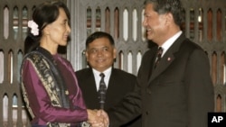 Burma's opposition leader Aung San Suu Kyi, left, shakes hands with Thai Deputy Prime Minister Chalerm Yubumrung during their meeting at Government House in Bangkok, Thailand, May 31, 2012. 