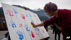 FILE - A Tibet supporter places his palm print on a banner during an event organized by Students for a Free Tibet to show solidarity with Tibetan political prisoners released in 2015 from Chinese jails in Dharmsala, India, Dec. 26, 2015. 