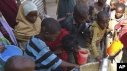 Children from southern Somalia get cooked food at a local NGO's compound in Mogadishu, Somalia, Sept.14, 2011.