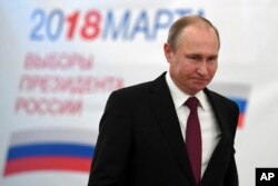 FILE - Russian President Vladimir Putin arrives to vote at a polling station during Russia's presidential election in Moscow, Russia, March 18, 2018. He won a new six-year presidential term in the vote, which opponents said was marred by fraud.