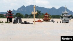 Submerged tombs are seen at a flooded village after heavy rainfall caused by tropical storm Son Tinh in Ninh Binh province, Vietnam, July 22, 2018.