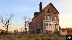 FILE - A photo shows a graffiti-marked abandoned home north of downtown Detroit, in the background, Oct. 24, 2013. 