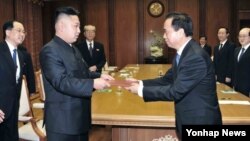 지난달 30일 방북 중인 중국 공산당 대표단으로부터 시진핑 공산당 총서기의 친서를 전달받은 김정은 북한 국방위원회 제1위원장(왼쪽). (자료사진)