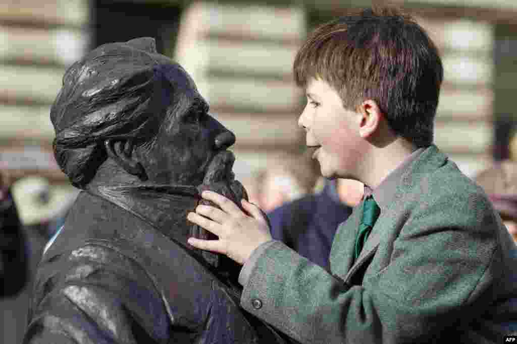 Oliver Dickens, 9, looks at the newly installed statue of his late great, great, great grandfather British writer Charles Dickens at Guildhall Square in Portsmouth.