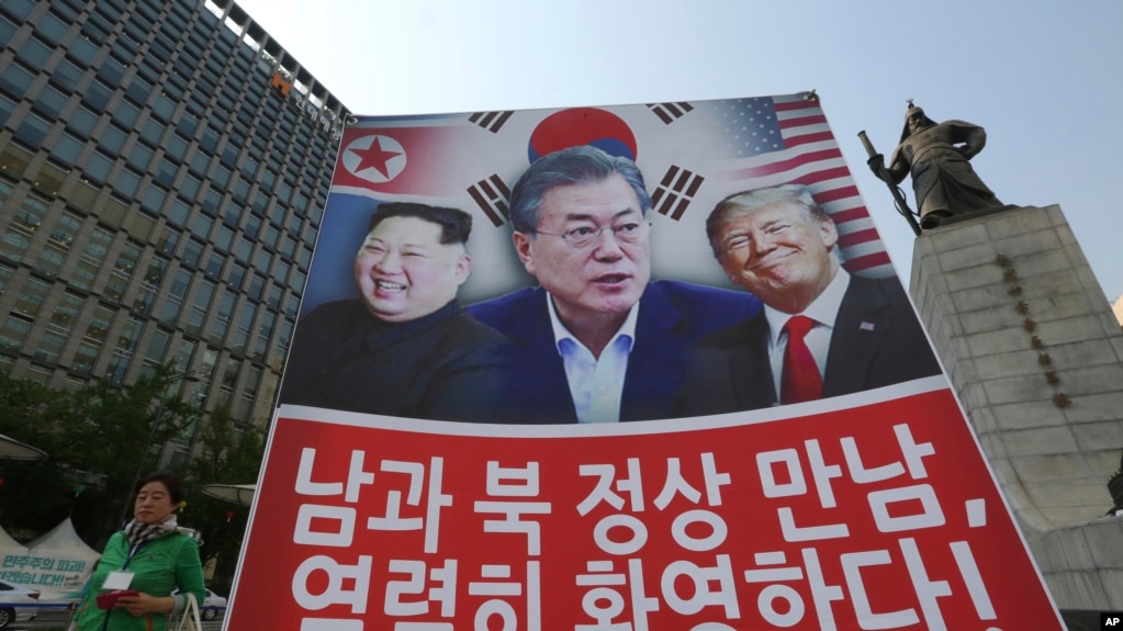 Biểu ngữ in hình TT Mỹ Donald Trump, phải, TT Hàn quốc Moon Jae-in và lãnh tụ Triều Tiên Kim Jong Un, trái, được trưng lên để ủng hộ cuộc họp thượng đỉnh liên Triều tại Seoul, Hàn quốc ngày 27/4/2018. (AP Photo/Ahn Young-joon)