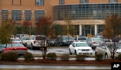 Cars sit in the parking lot, Oct. 27, 2015, in Columbia S.C. The Justice Department opened a civil rights investigation Tuesday after Senior Deputy Ben Fields flipped a student backward in her desk and tossed her across the floor for refusing to leave her