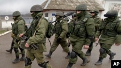 FILE - In this March 20, 2014 photo, Pro-Russian soldiers march outside an Ukrainian military base in Perevalne, Crimea.