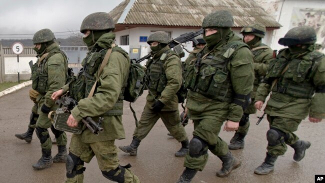 亲俄罗斯士兵在克里米亚的乌克兰军事基地外行进。（2014年3月20日）