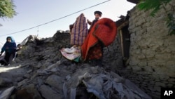 Rehmatud Din (c) who lost his daughter in Monday's earthquake, salvages what he can from his destroyed house caused by Monday's earthquake in Chitral town, northern Pakistan, October 29, 2015.