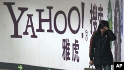 In this file photo, a woman walks past a Yahoo billboard in a Beijing subway in this March 17, 2006. (AP Photo, File)