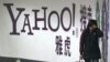 Seorang perempuan berjalan melewati papan iklan yang bertuliskan Yahoo yang terpasang pada stasiun kereta bawah tanah di Beijing, pada 17 Maret 2006. Yahoo mulai 1 November 2021 memutuskan untuk menghentikan operasinya di China. (AP Photo, File)