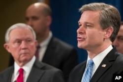 Attorney General Jeff Sessions listens as FBI Director Christopher Wray speaks during a news conference about the arrest of Cesar Sayoc, 56, of Aventura, Fla., in the package bomb case, at the Department of Justice, Oct. 26, 2018, in Washington.