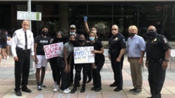 在首都华盛顿近郊马里兰州洛克维尔市举行的反警察暴力集会上，警察负责人与抗议者友好合影。(2020年6月5日)