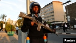 FILE - A riot policeman stands guard outside the main gate of the National Assembly in Kenya's capital, nairobi, Dec. 18, 2014. 